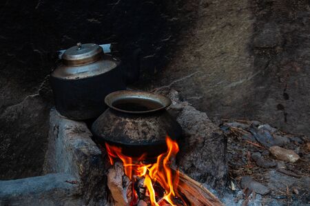 Traditional asian way to cook, old pot and kettle in fireplaceの写真素材