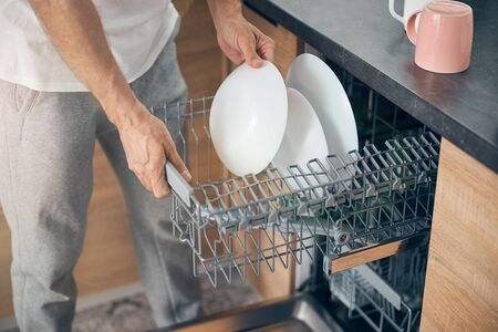 Focused photo on male hands setting the dishesの写真素材