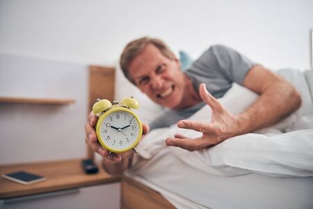 Focused photo on angry man oversleeping his meetingの写真素材