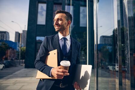Handsome brunette man staying near office alone