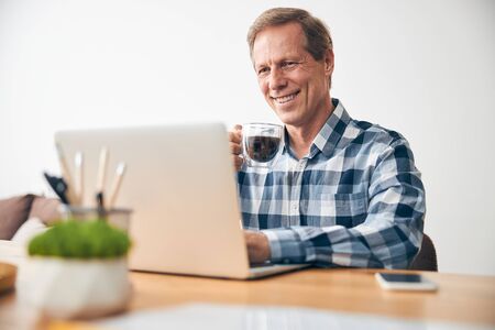 Sincere mature man going to drink his coffeeの写真素材