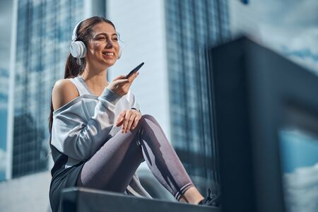 High-spirited lady holding a phone in her handの写真素材