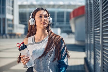 Stylish young lady holding a plastic bottleの写真素材
