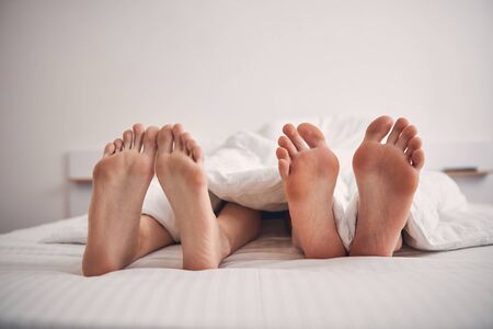 Two people lying under sheet and relaxing