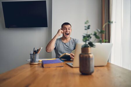 Successful young man raising hand of happinessの写真素材