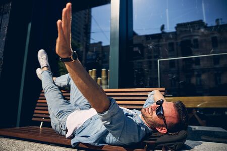 Handsome brunette man waving his hand to friend