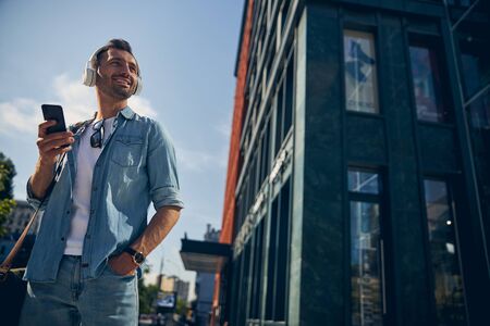 Handsome brunette male person looking at modern buildings
