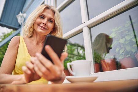 Pleased female reading a text message outsideの写真素材