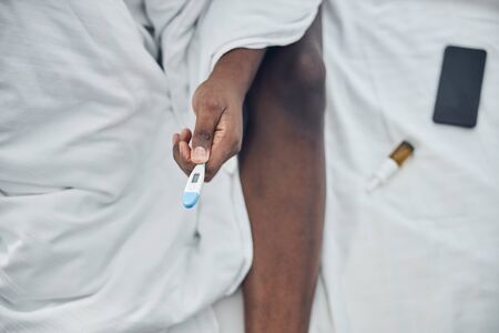 Focused photo on thermometer that being in male hand