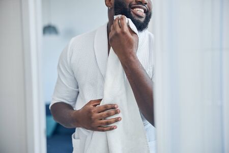 Close up of joyful man that taking care of his skinの写真素材