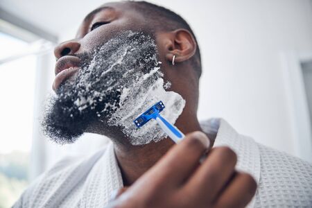 Close up of young man that shaving beardの写真素材