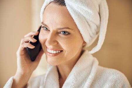 Smiling young Caucasian woman using her gadgetの写真素材