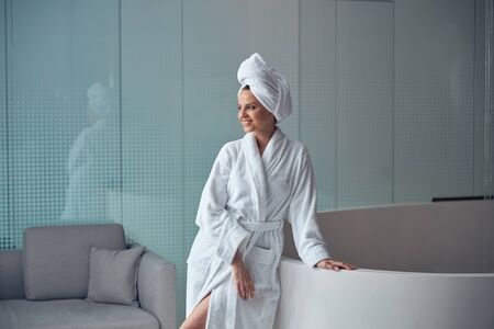 Smiling relaxed good-looking lady standing alone indoorsの写真素材