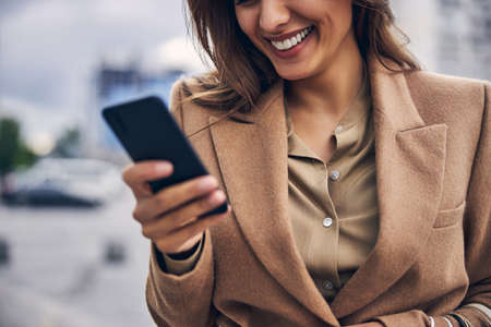 Contented woman staring at her smartphone screen
