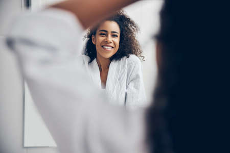 Cheerful female in a bathrobe standing in the bathroomの写真素材