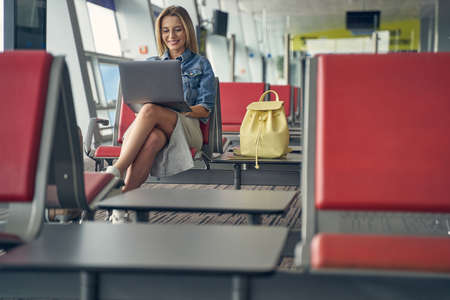 Positive delighted blonde woman staring at her laptopの写真素材