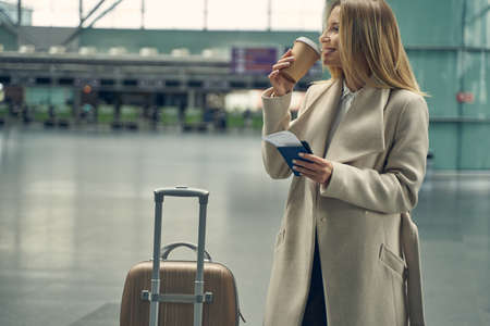 Positive delighted young blonde enjoying her coffeeの写真素材