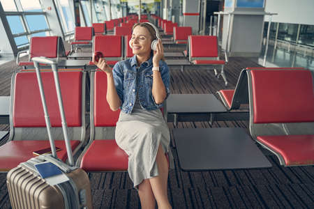 Positive delighted female person listening to music