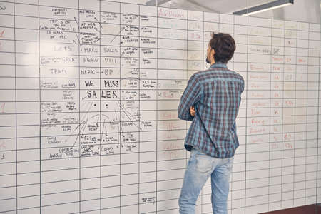 Male worker standing in front of whiteboard in office