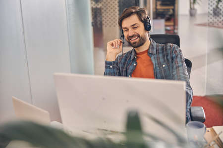 Joyful young man working in modern office