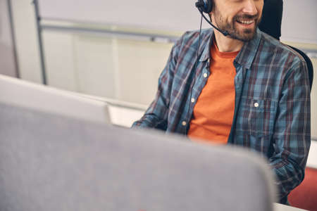 Cheerful male worker sitting at the table in office