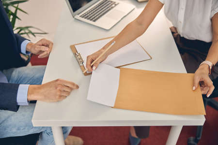 Young woman and man working with papers in officeの写真素材