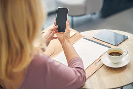 Close up of blonde female looking at her gadget