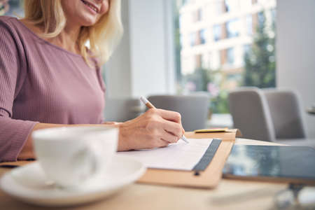 Positive delighted blonde looking at her notesの写真素材