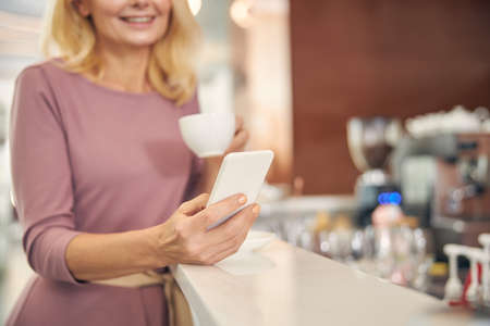 Close up of blonde female looking at her telephoneの写真素材
