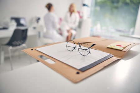 Close up of glasses lying on the notebookの写真素材