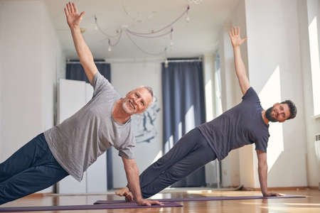 Strong men practicing a side plank poseの写真素材