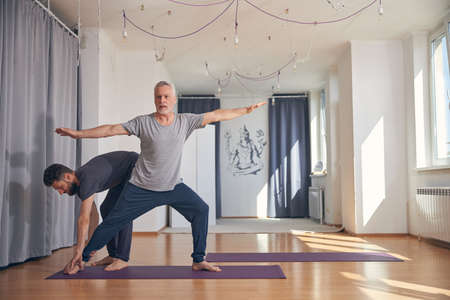 Beginner yogi practicing yoga in a gymの写真素材