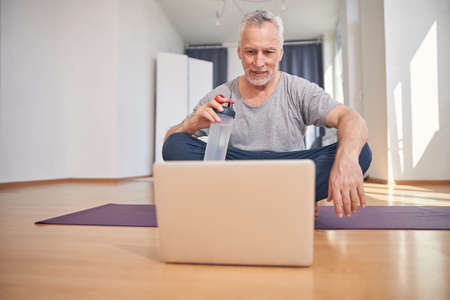 Pleased male athlete with a bottle of waterの写真素材