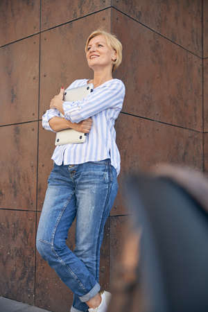 Lady standing against the corner of a building