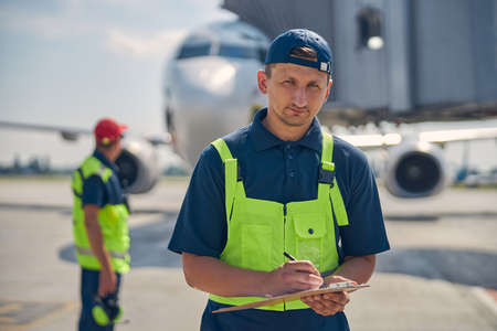 Man holding a clipboard in his handの写真素材
