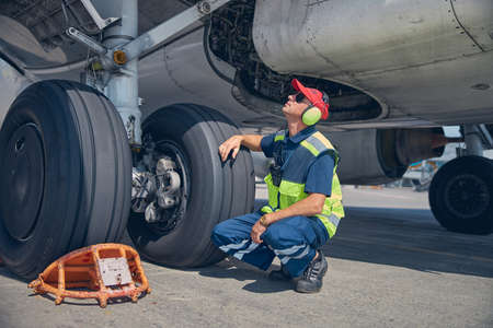 Qualified young technician inspecting the undercarriage axleの写真素材