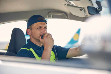 Airport car driver speaking into the microphone