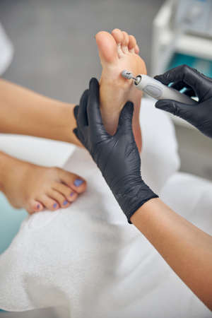 Nail artist doing hardware pedicure for womanの写真素材