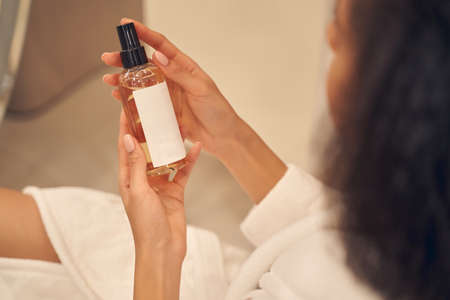 Liquid cosmetic product in hands of young woman