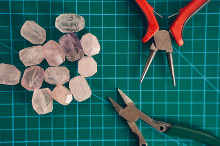 Photo of jewelry set for making handmade things isolated on green backgroundの写真素材