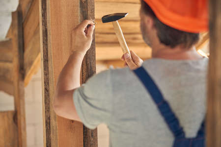 Skilled Caucasian carpenter working inside a house