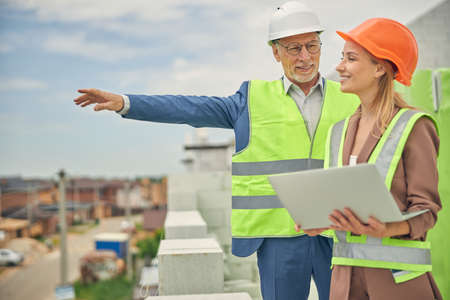 Male worker in eyeglasses showing something to a contractor