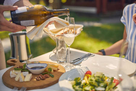 Man pouring champagne in glass at the dinnerの写真素材