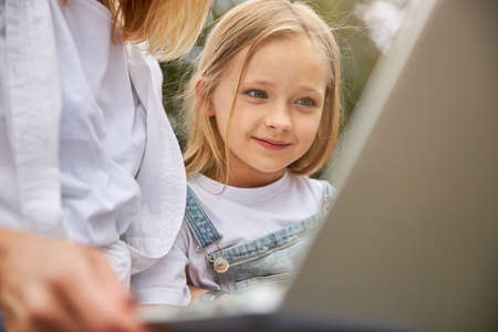 Good young girl smiling and feeling happy near the mother