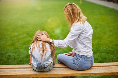 Female taking care and attention for her daughter in the outdoorsの写真素材