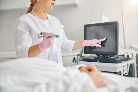 Doctor with a hydrodermabrasion device in one hand