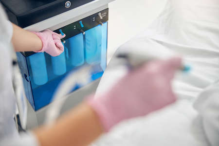 Dermatologist in medical gloves starting a cosmetic procedure
