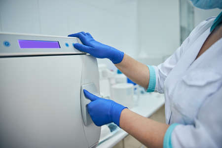 Nurse using modern machine for disinfection equipment after patient