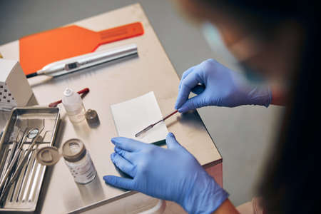 Professional orthodontist working with material for treating teeth