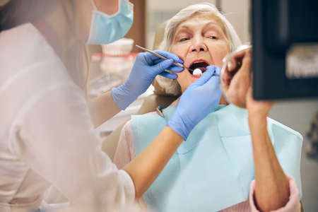 Woman at the dentist chair during dental procedureの写真素材